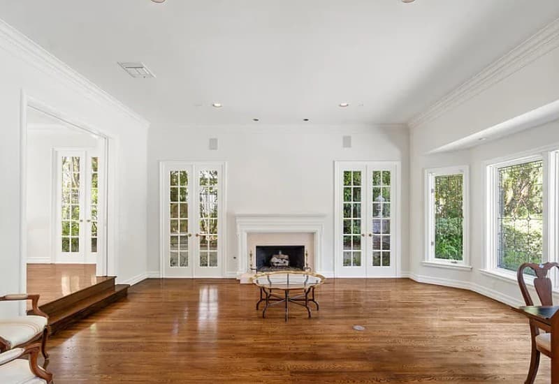 Bienveneda Estate formal living room with fireplace, French doors, and hardwood floors