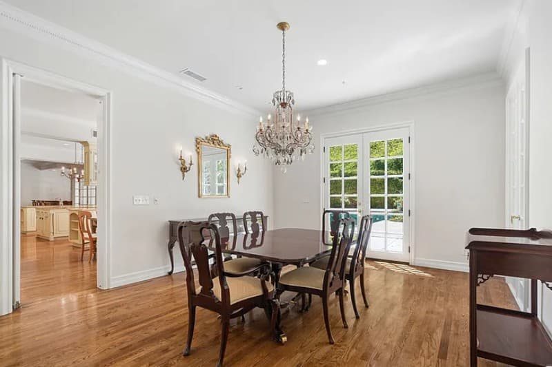 Bienveneda Estate formal dining room with crystal chandelier and French doors to the pool