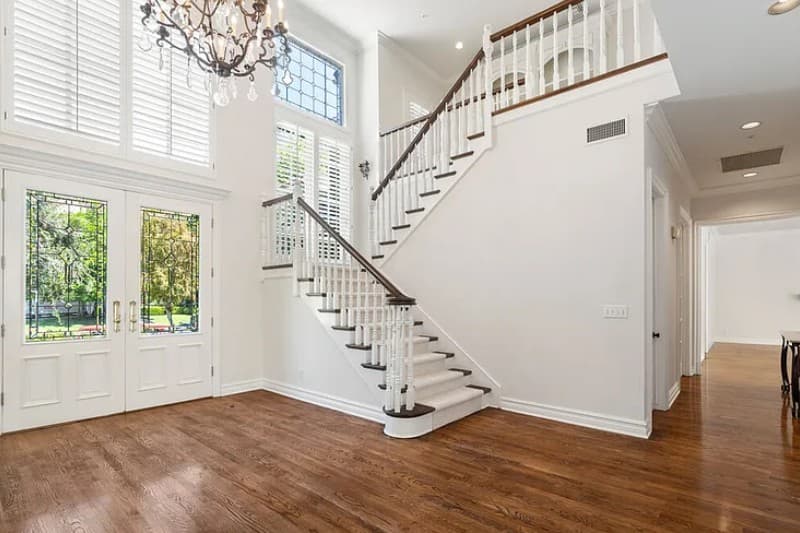 Bienveneda Estate grand foyer with double-height ceiling, staircase, and leaded-glass entry doors